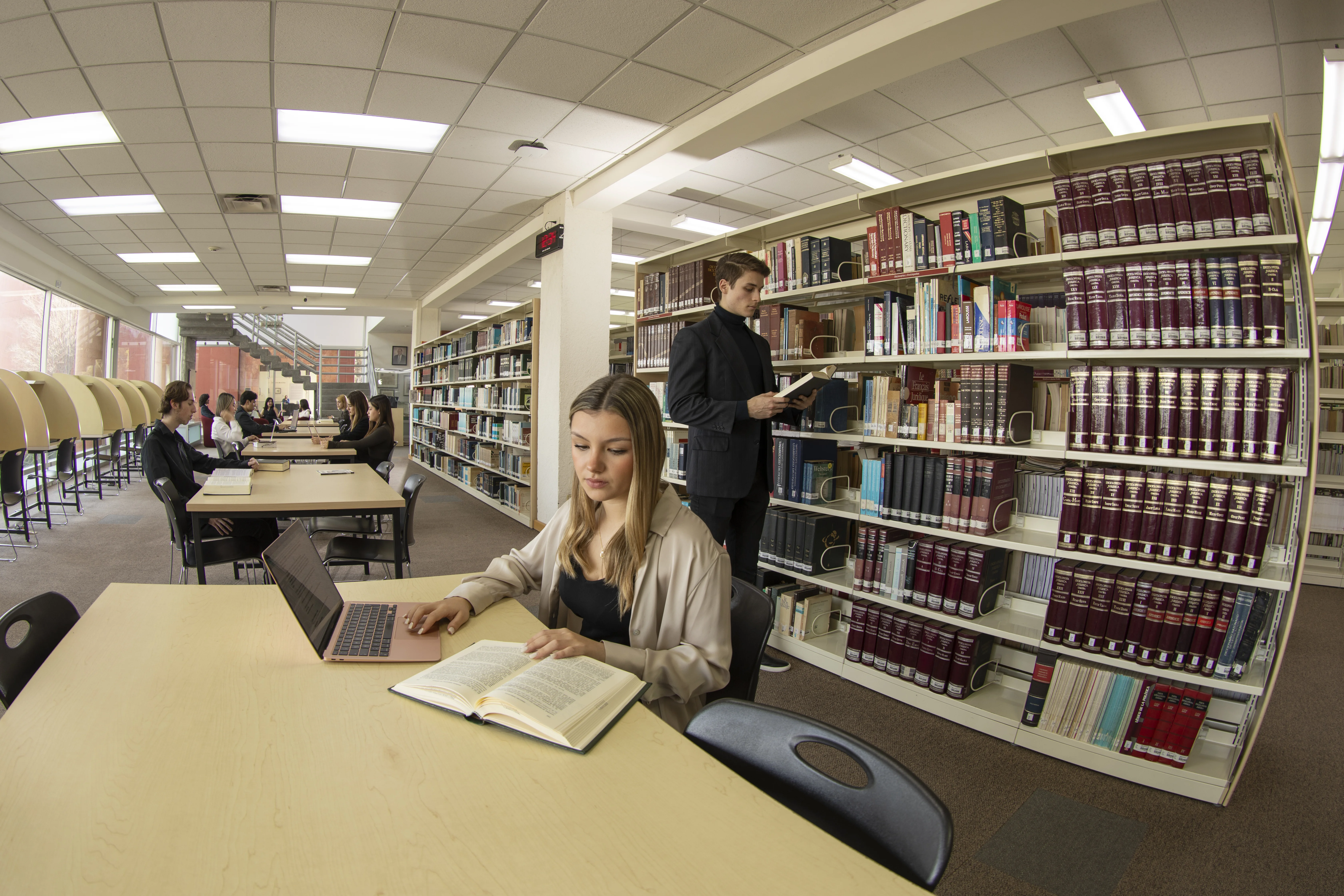 Estudiantes de la FLDM estudian y consultan libros en la biblioteca de la facultad.