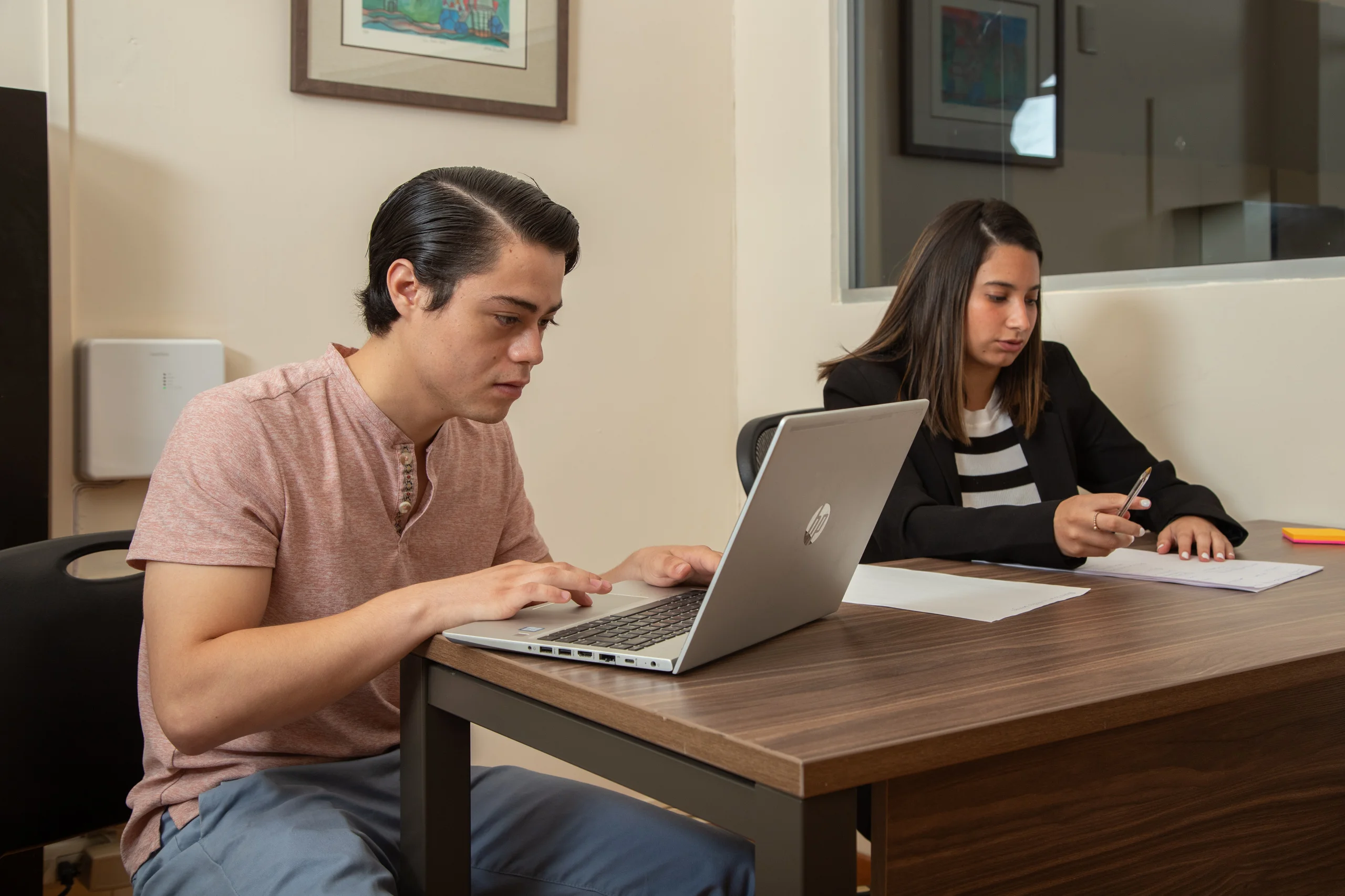 Estudiantes de la FLDM revisan documentos y trabajan en una laptop en el Centro Juridico Gratuito