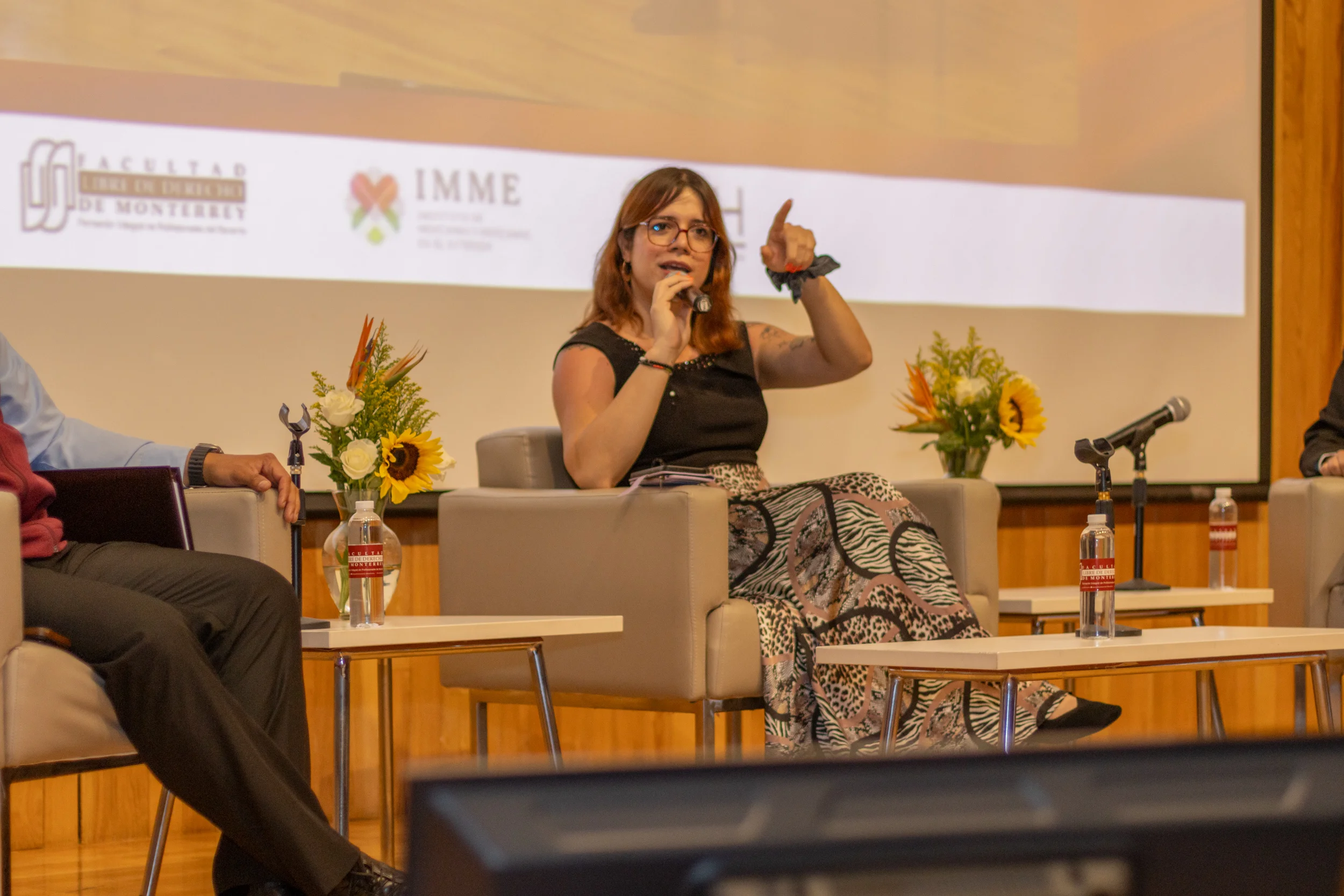 Panelista habla con microfono durante un evento academico de la FLDM