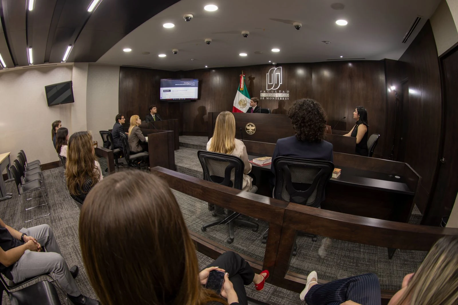 Estudiantes y profesores durante una sesión práctica en la Sala de Juicios Orales de la FLDM.